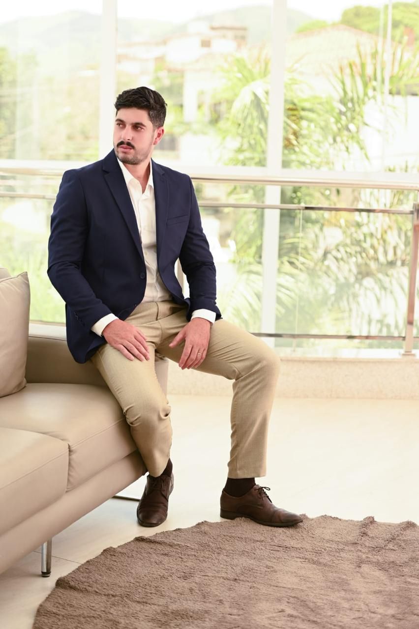 Nagib Neto em pose lateral, de blazer azul-marinho